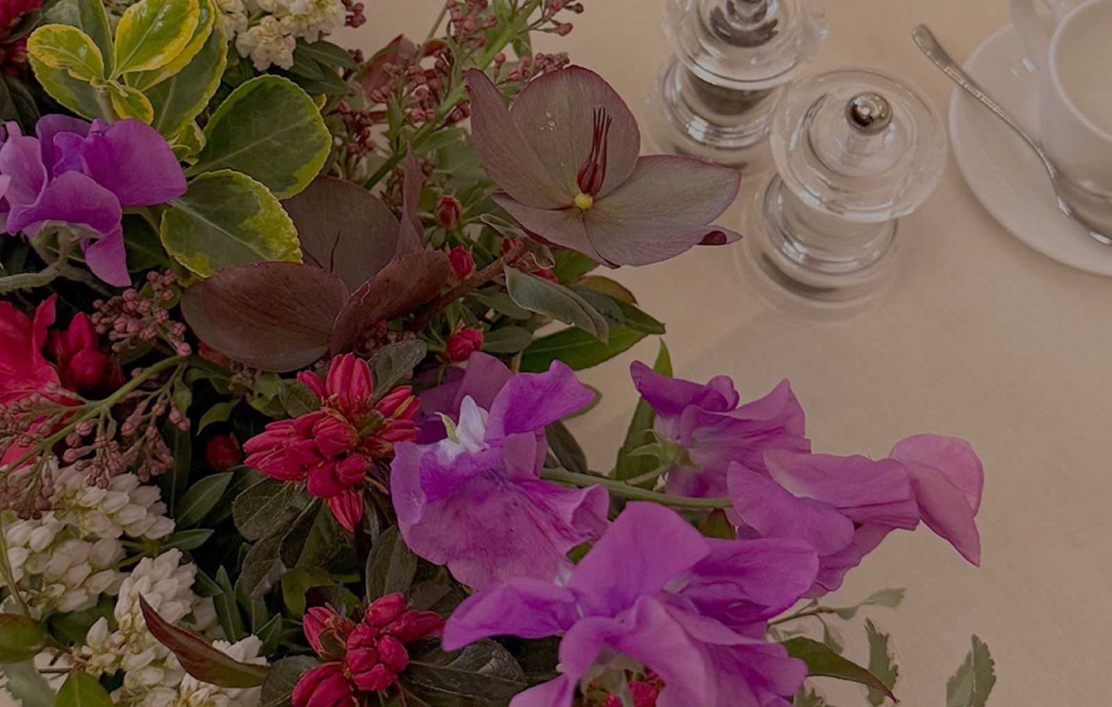 Long and low banquet arrangement with sweet peas and lilac